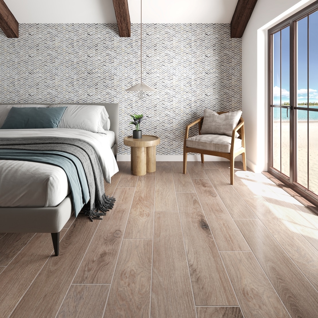 Beach house bedroom with tile that looks like wood planks, mosaic tiled wall, and glass door leading to the beach.