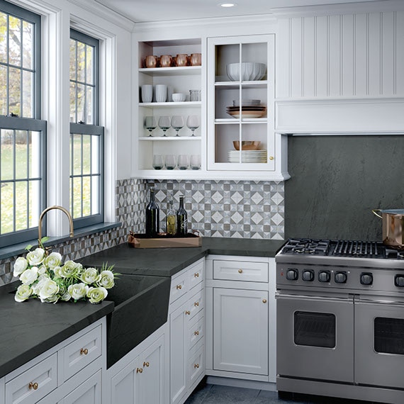 Kitchen with black soapstone countertops and geometric backsplash.