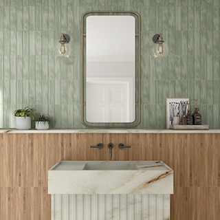 Natural quartzite bathroom vanity with wood look tile and mint green tile backsplash, wall-mounted faucet, natural quartzite shelf, framed mirror and globe lighting.