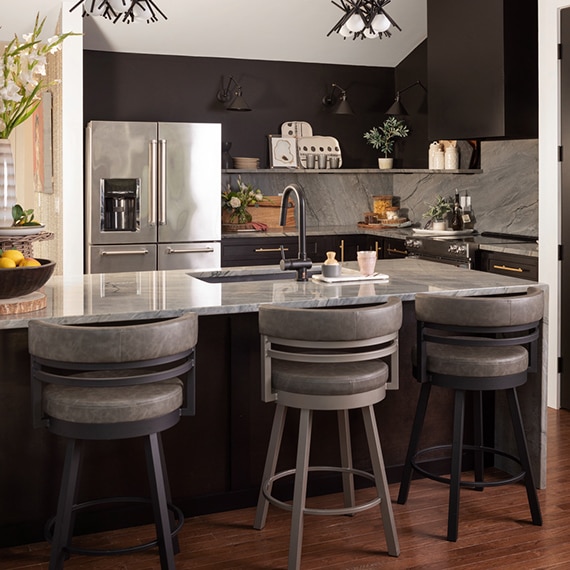 Kitchen with gray natural quartzite countertops & backsplash, island with sink, floating quartzite shelves, modern chandelier.
