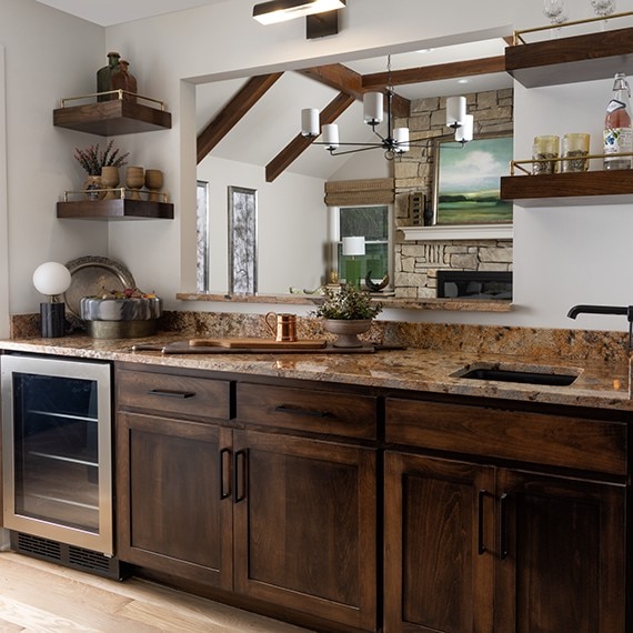 Wet bar with dark brown wood cabinets and a light brown granite countertop.