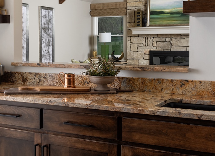 Wet bar with light brown granite countertop and a decorative vase.