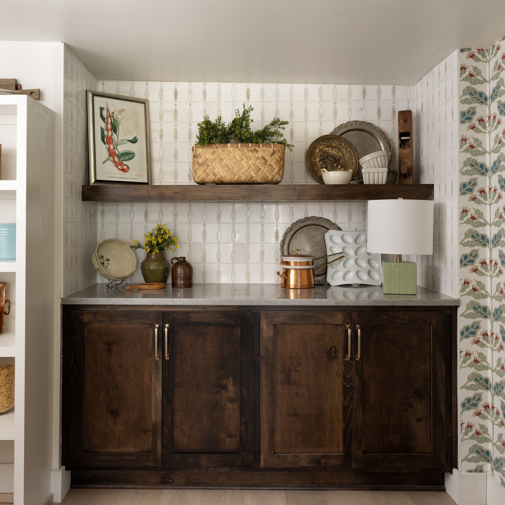 Pantry with dark brown wood cabinets and white mosaic on the backsplash.