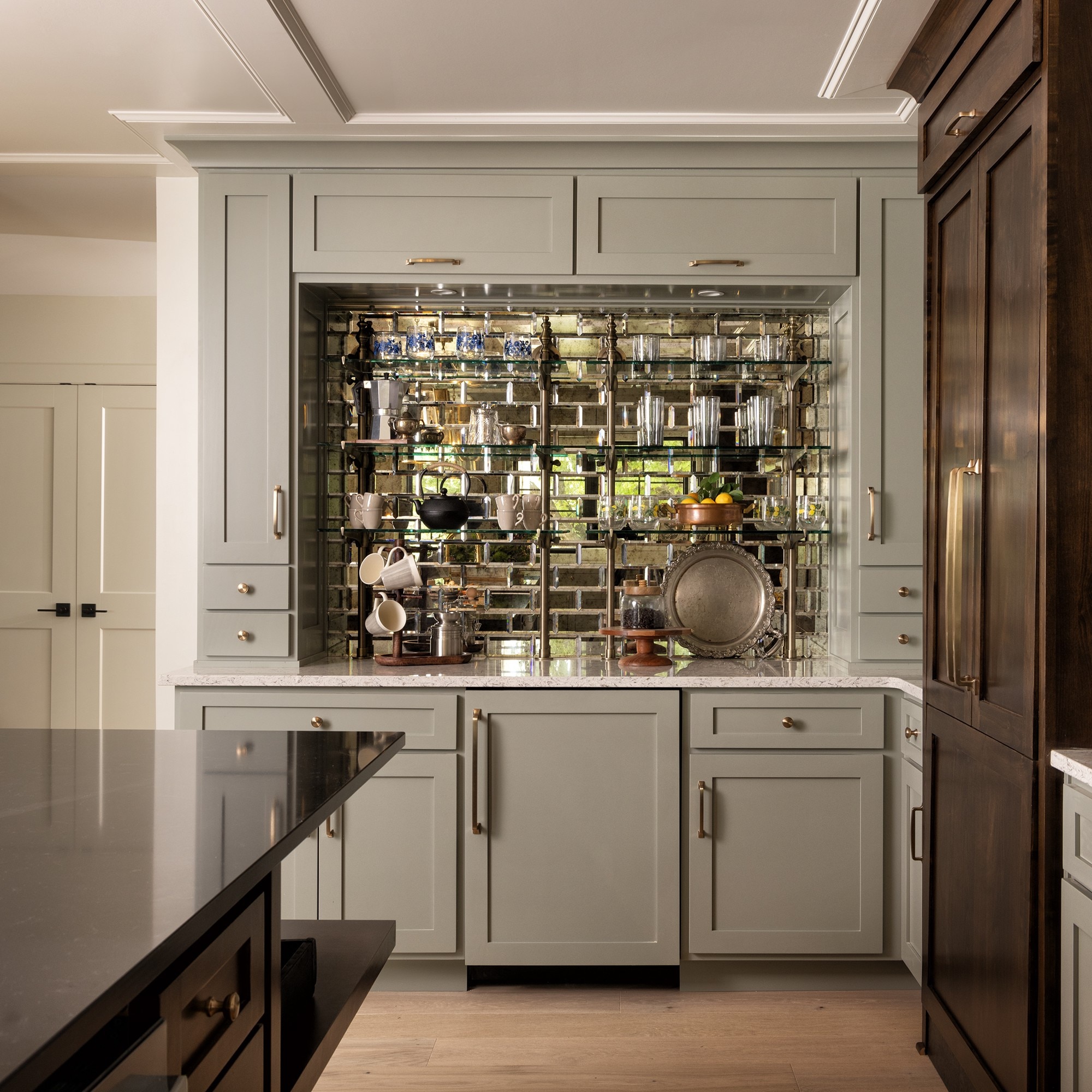 Wet bar with light gray cabinets, glass mosaic backsplash, and a beige quartz countertop.