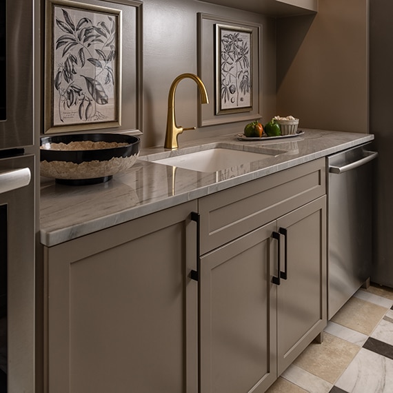 Pantry sink with gray cabinets, a white quartzite countertop, a checkered floor with white marble look floor tile, gray marble look floor tile, and beige natural stone floor tile.
