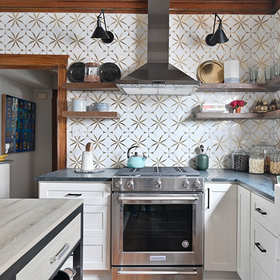 Farm house kitchen with white marble mosaic with embedded brass wall tile backsplash, black soapstone countertops, farm sink, and wood beams.