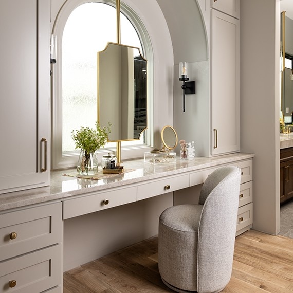 Vanity with white cabinets and drawers with a beige marble look quartzite slab on the countertop.