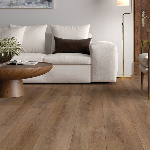 Living room with luxury vinyl tile (LVF/LVT) that looks like wood flooring, white couch, wood chair with white cushions, and wood coffee table, and brass floor lamp.