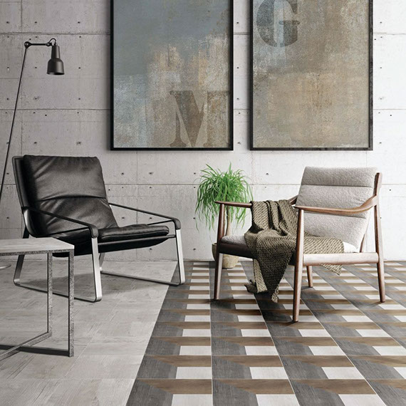 Living room with industrial décor, floor tile that looks like weathered wood with natural wood & seasoned wood accents, brown leather chair and linen chair.