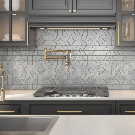 Kitchen with gray-blue geometric natural stone mosaic backsplash, white quartz countertop, dark wood cabinets with glass doors.