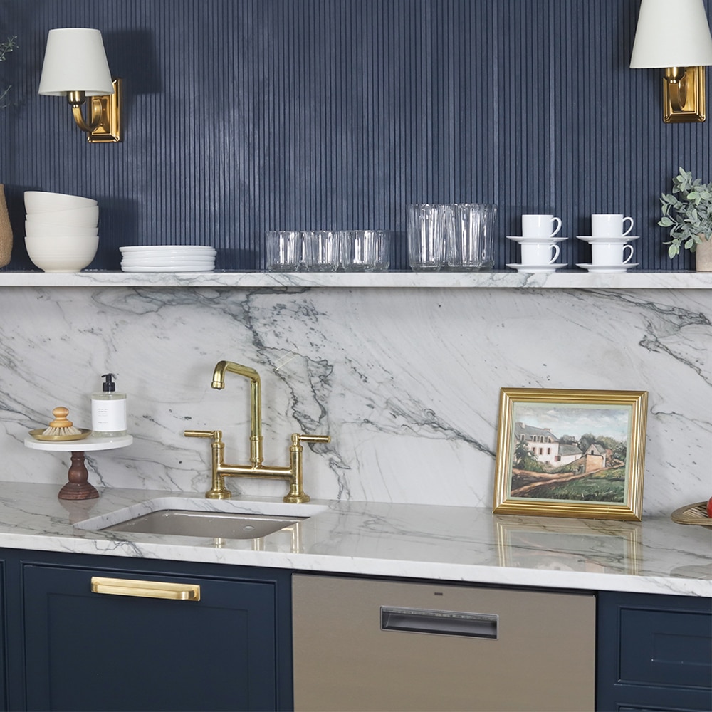Kitchen with white quartzite countertop and backsplash, blue cabinets, and blue walls.