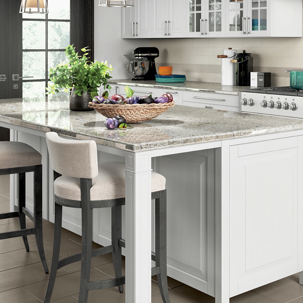 Kitchen with center island, white granite countertops, white sitting chairs, and white cabinets.