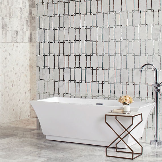 Elegant bathroom with gray marble floor tile, marble & mirror wall tile behind soaker bathtub, and marble mosaic shower wall.