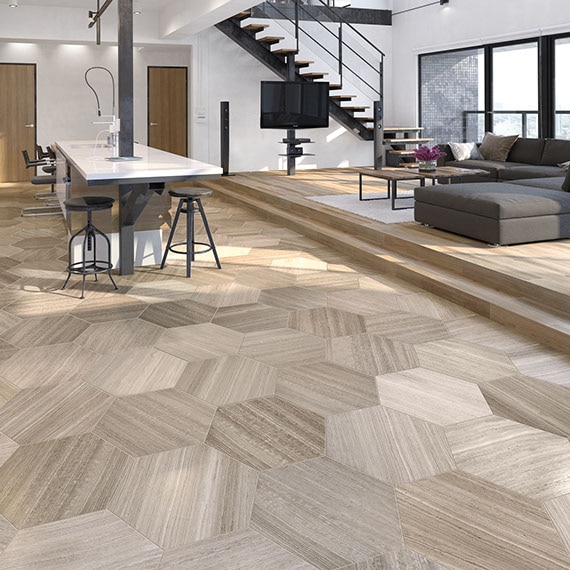 Open concept kitchen and living space with twenty inch limestone hexagon floor tile, industrial modern furnishings in the background.