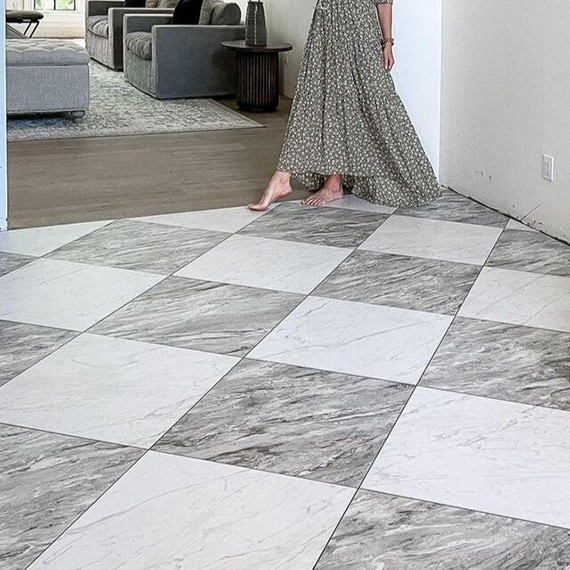 Newly renovated foyer with gray and white marble-look floor tile in checkerboard pattern.