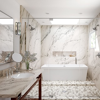 Elegant bathroom with cream with gray veining quartzite covering vanity counter and wet room shower walls, free-standing tub in front of long shower niche, marble mosaic wet room flooring tile.