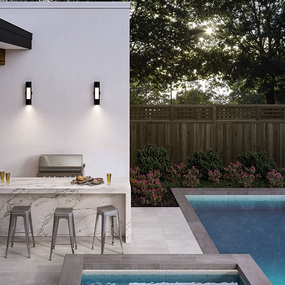 Outdoor kitchen with off-white & gray veining waterfall island, pool & spa with gray tile and white tile pool deck.