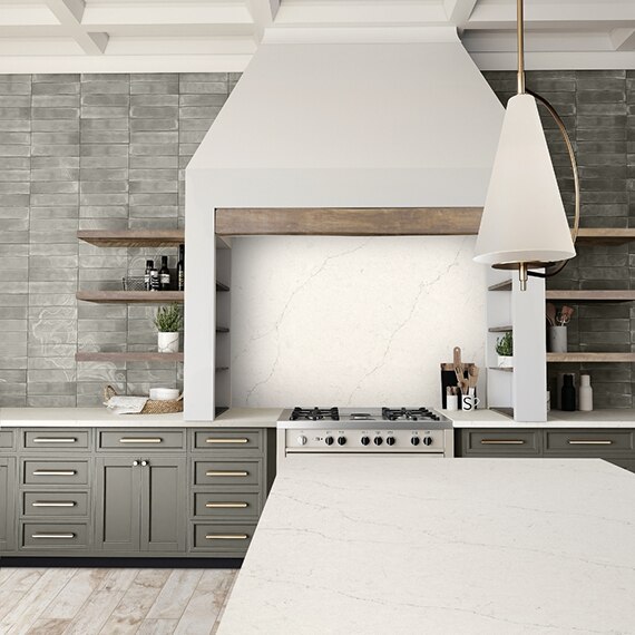 Modern farmhouse kitchen with off-white quartz island countertop and stovetop backsplash, natural wood floating shelves on gray subway tile.