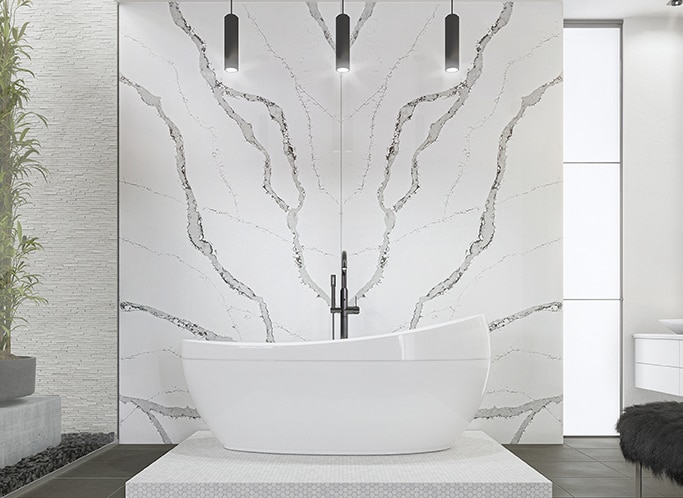 Bathroom with white tub and black and white marble on back wall, and white walls, and gray floor.