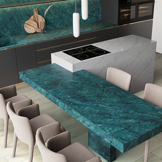Kitchen with blue quartz countertops, light wood floors, and beige sitting chairs.