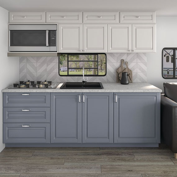 RV kitchenette backsplash of pre-cut gray marble and white marble chevron mosaic tile, gray granite countertop, white upper cabinets, and gray lower cabinets.