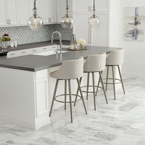 Transitional kitchen with marble-look porcelain floors and mosaic backsplash. Smooth grey solid top counter on the island with three glass pendant lights.