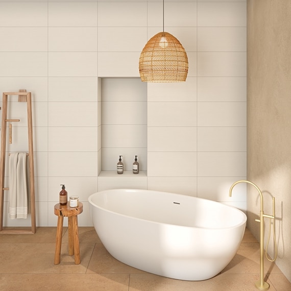 Minimalist bathroom with soaker tub on slip-resistant terracotta-look floor tile, antimicrobial off-white wall tile with niche, and wicker pendant lighting.