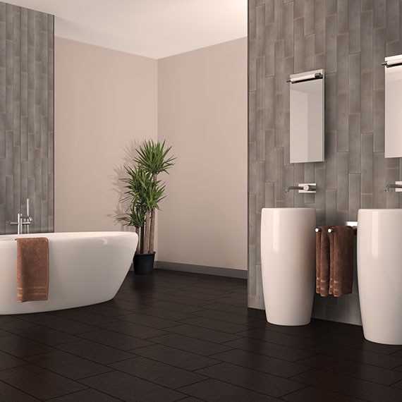 Spacious bathroom with tall ceilings accentuated by metallic-look linear tile arranged in a vertical pattern. Soaker tub and double vanity in curvy shapes.
