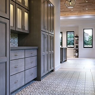 Butler's pantry with dark grey, glass-front cabinetry and grey and white encaustic floor tile.