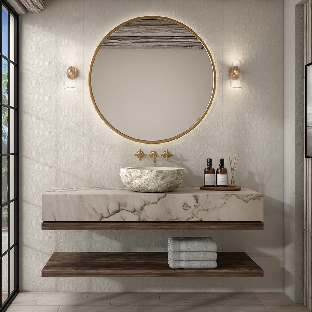 Bathroom sink with white quartzite slab countertop, round stone sink, wood shelves, and white walls.