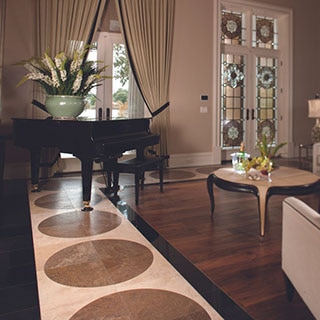 Elegant living room with accents of black granite, beige & white travertine floor tile, black baby grand piano, dark & light wood coffee table.