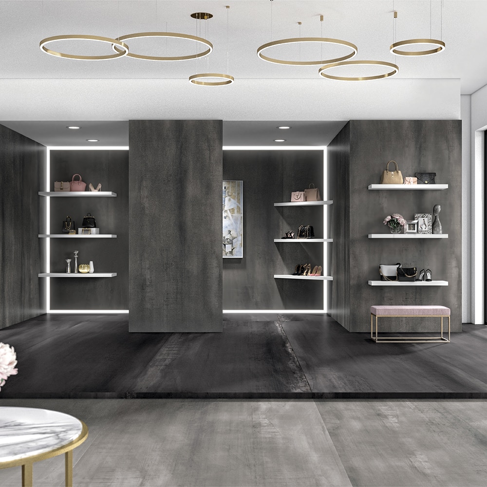 Boutique shelves with handbags, and gray metal look walls and floors.