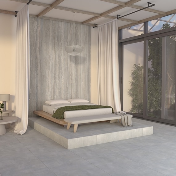 Bedroom with white canopy over a king-sized bed on gray stone look porcelain slab flooring and raised platform, and gray marble look porcelain slab headboard wall.
