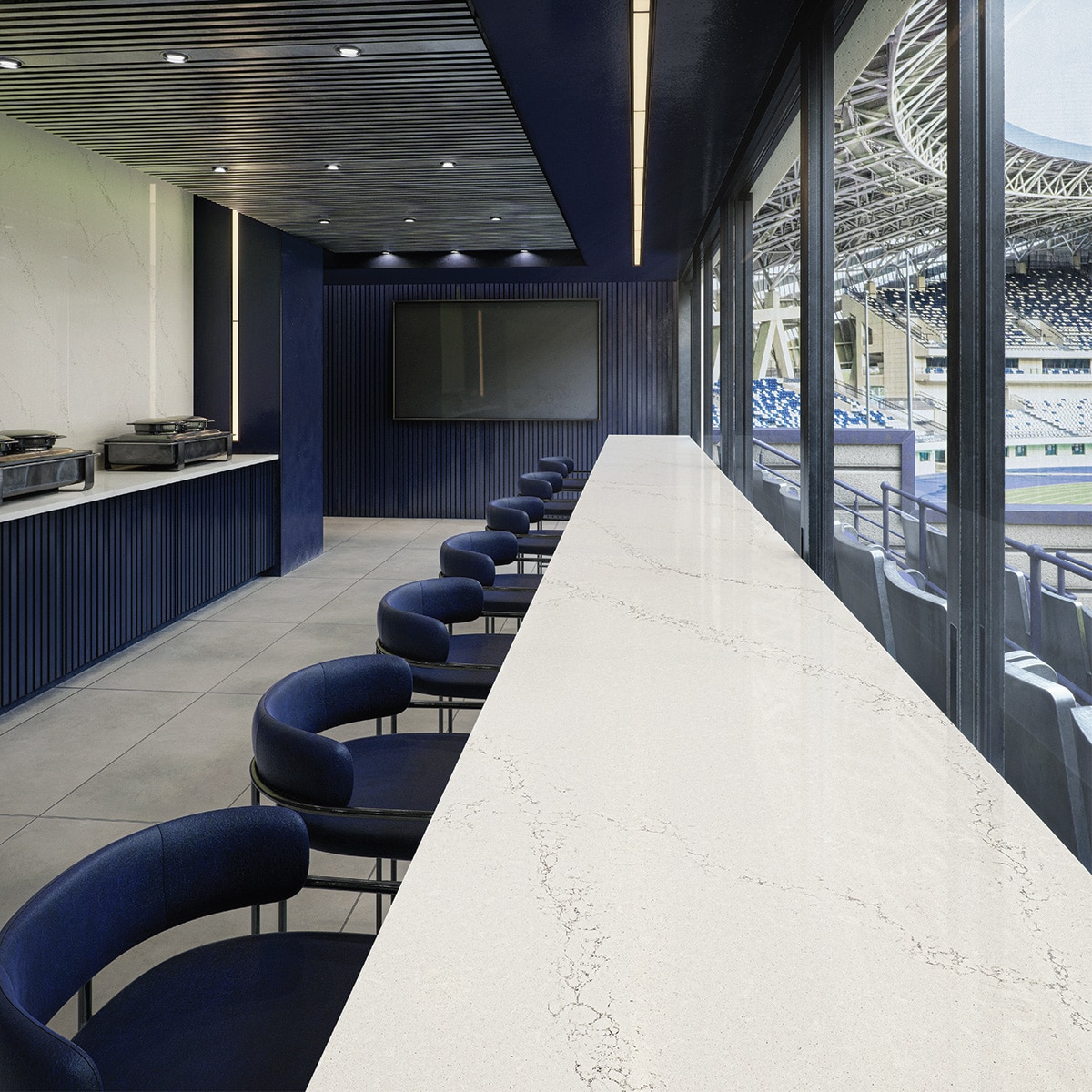 Stadium indoor bar seating area with black chairs and a white marble slab table.