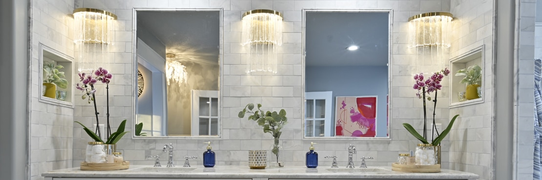 Bathroom vanity with dual undermount sinks, natural quartzite countertops, marble subway tile, marble framed mirrors, and two wall niches.