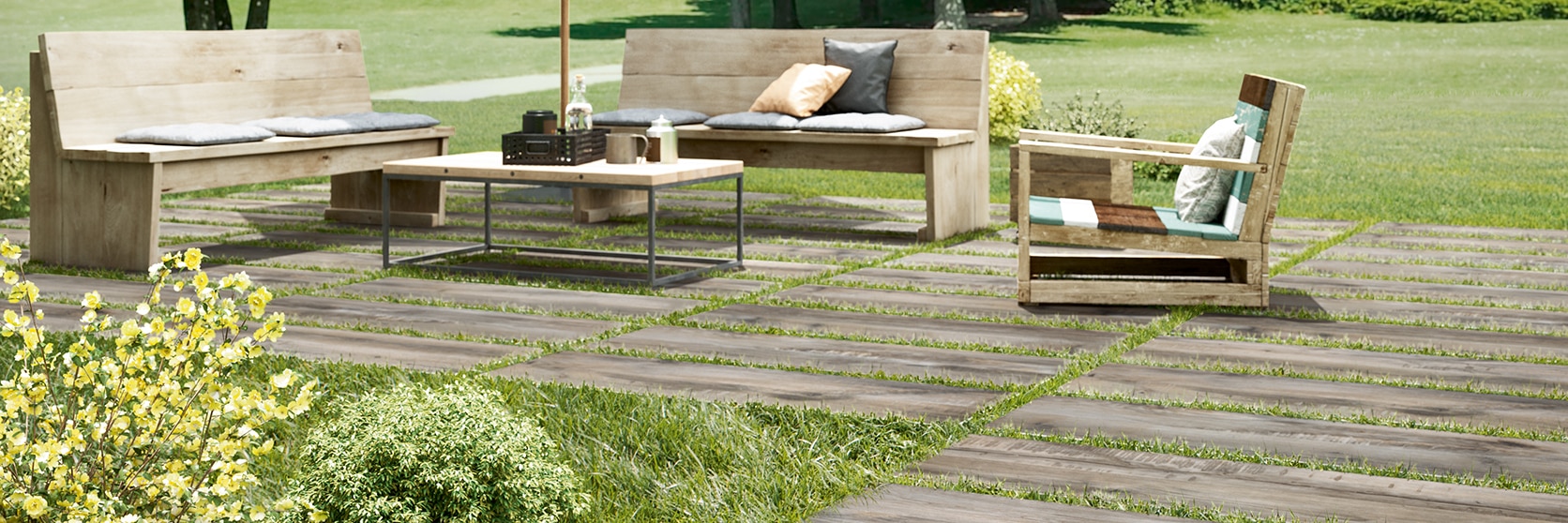 Lawn furniture on 16" x 48" 2 centimeter porcelain pavers that look like seasoned wood, set on top of green grass.