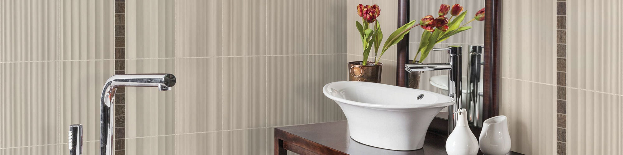 Bathroom with beige texture wall tile with brown accents, wood vanity with white vessel sink and silver polished faucet.