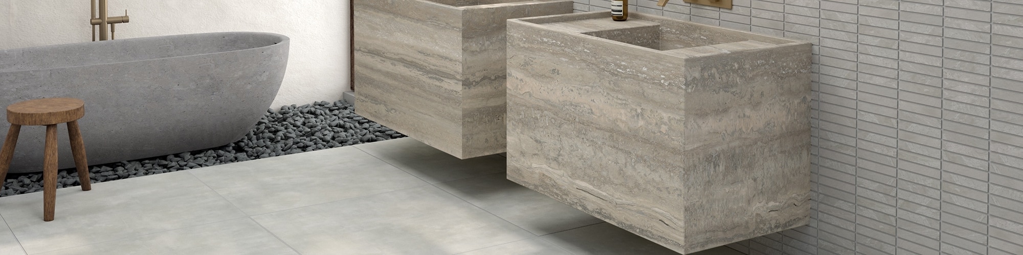 Bathroom with gray soaker tub set in pebbles, gray stone look tile flooring, dual floating vanities that look like gray natural quartzite, and gray 1x6 mosaic backsplash.