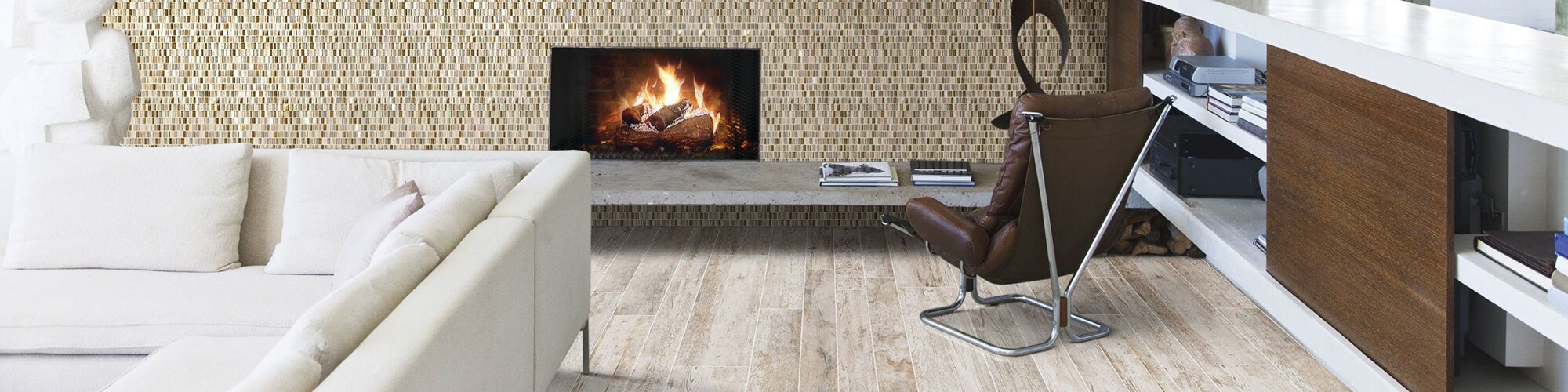 Modern living room with feature wall of neutral color glass mosaic wall tile, fireplace with floating hearth, brown leather & silver metal chair.
