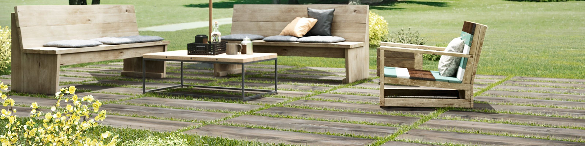 Lawn furniture on 16" x 48" 2 centimeter porcelain pavers that look like seasoned wood, set in green grass.