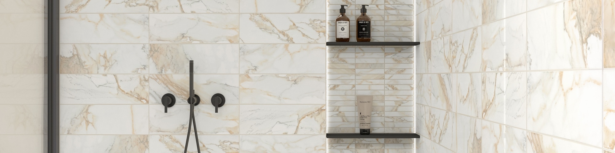 Large shower with white & beige marble wall tile, inset with marble mosaic tile, shelves, and perimeter lighting, and black matte fixtures.