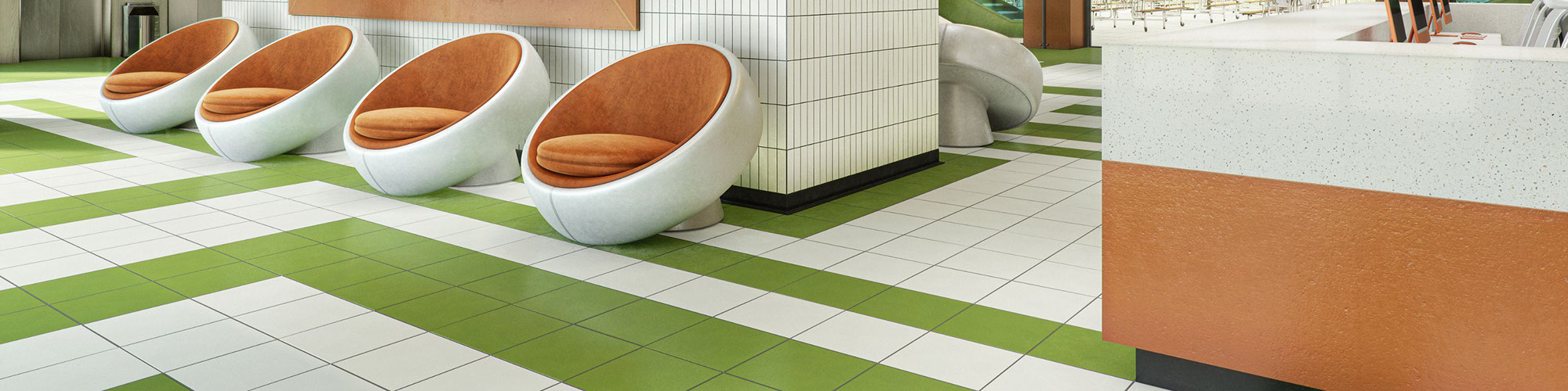Room with green and white floor tile, white subway tile on walls, orange accents, and white and orange oval sitting chairs.