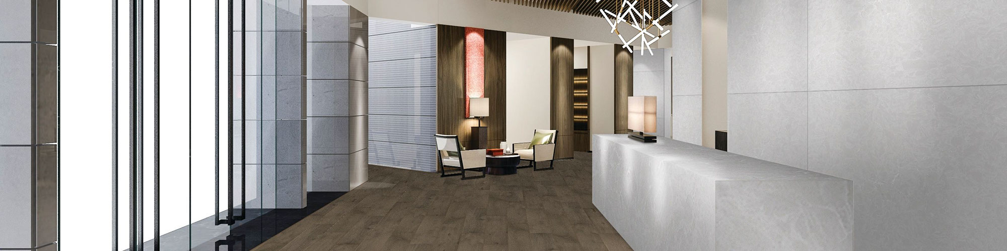 Hotel lobby with front desk countertop & walls of white quartz that looks like stone, wood look tile flooring, and pendant lighting.