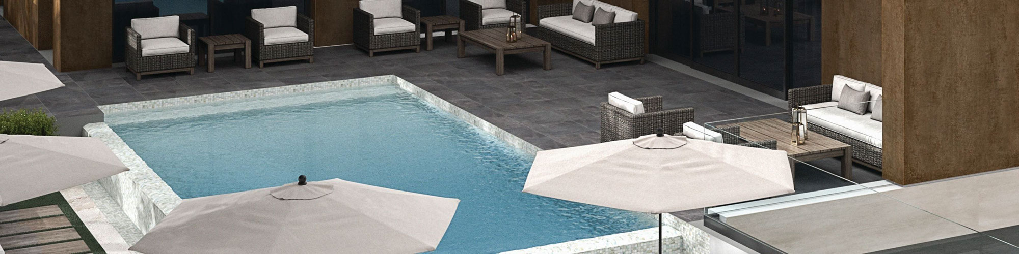 Backyard with metallic look cladding, wicker lounge chairs around pool with dark gray stone look tile and wood look paver pool deck.