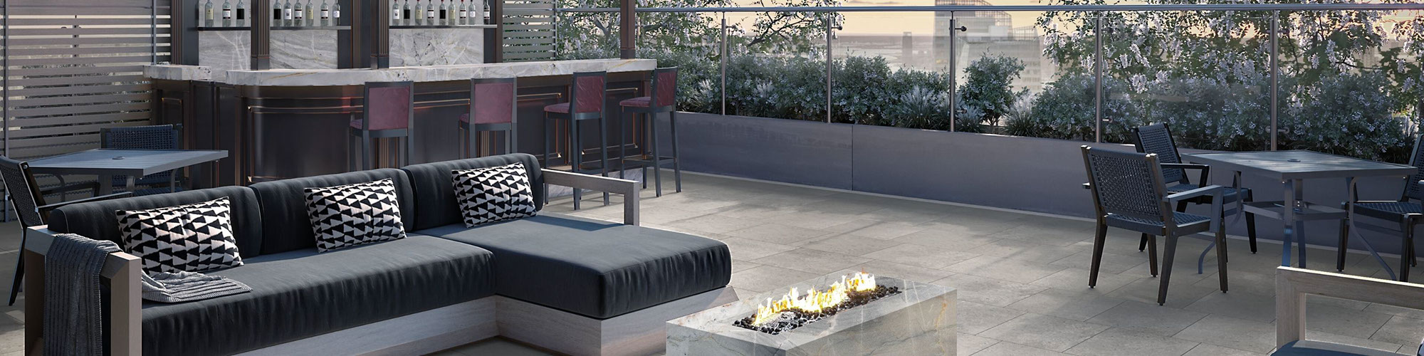Rooftop bar with gray quartzite slab firepits, countertops, and backsplash, gray floor tile that looks like stone, black sectionals with chaise lounges.