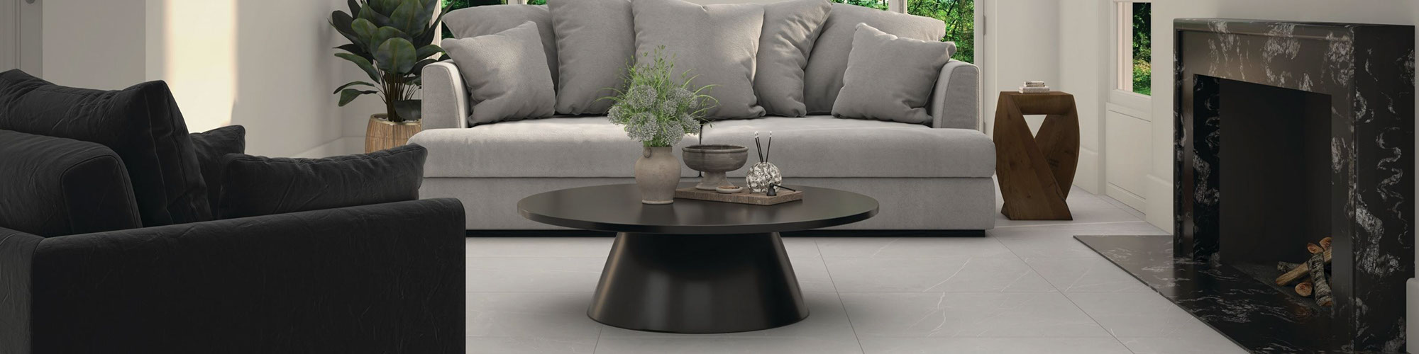 Living room with light gray tile floor that looks like marble, black & white granite fireplace, light gray velvet over-stuff sofa, and black velvet chair.