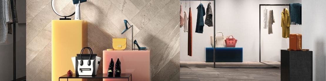 Dress shop with feature wall of beige stone-look tile in a herringbone pattern, dark gray stone-look floor tile, shoes & accessories on yellow & pink blocks.