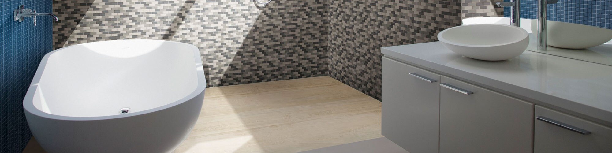 Bathroom with soaker tub, large shower with neutral-colored variegated mosaic wall tile and wood-look shower floor tile.