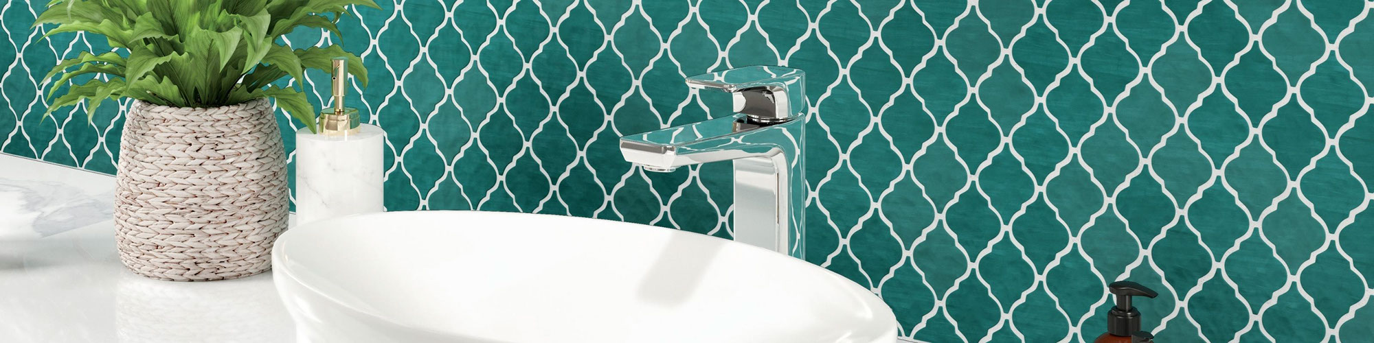 Bathroom vanity with teal arabesque mosaic backsplash, vessel sink on white porcelain slab countertop, silver polish faucet, small plant in wicker basket.