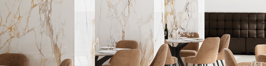 Elegant restaurant with white stone tables, thick cushioned chairs, and walls featuring white marble look porcelain slabs with bold rust & gray striations.